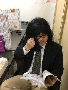 同人誌を読んで涙ぐむ男性