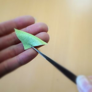 ピンセットで布を三角に折る様子